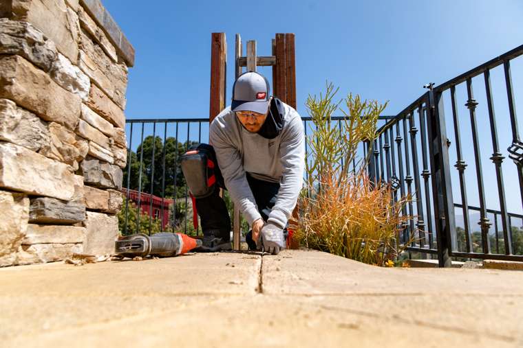 PMP technician cutting out a failed pool mastic joint with a precision saw