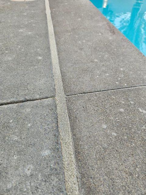 Grey sand finish against an aggregate pool deck